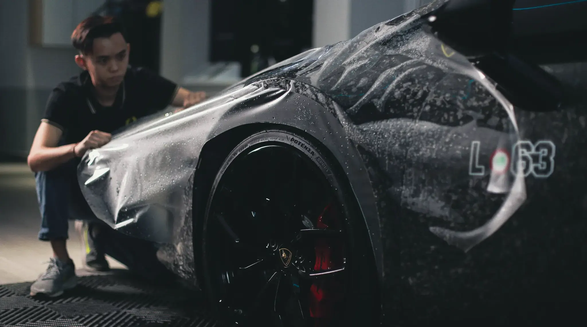 QUAD Film installer fitting protective film over a car panel